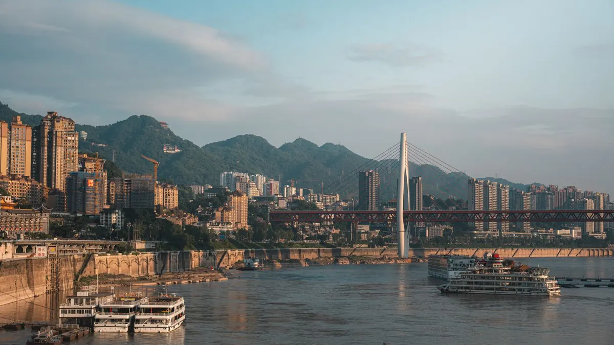 Riverside skyline, a cable-stayed bridge, and hills in Chongqing